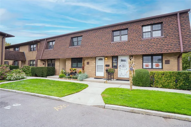 front view of a brick house with a yard