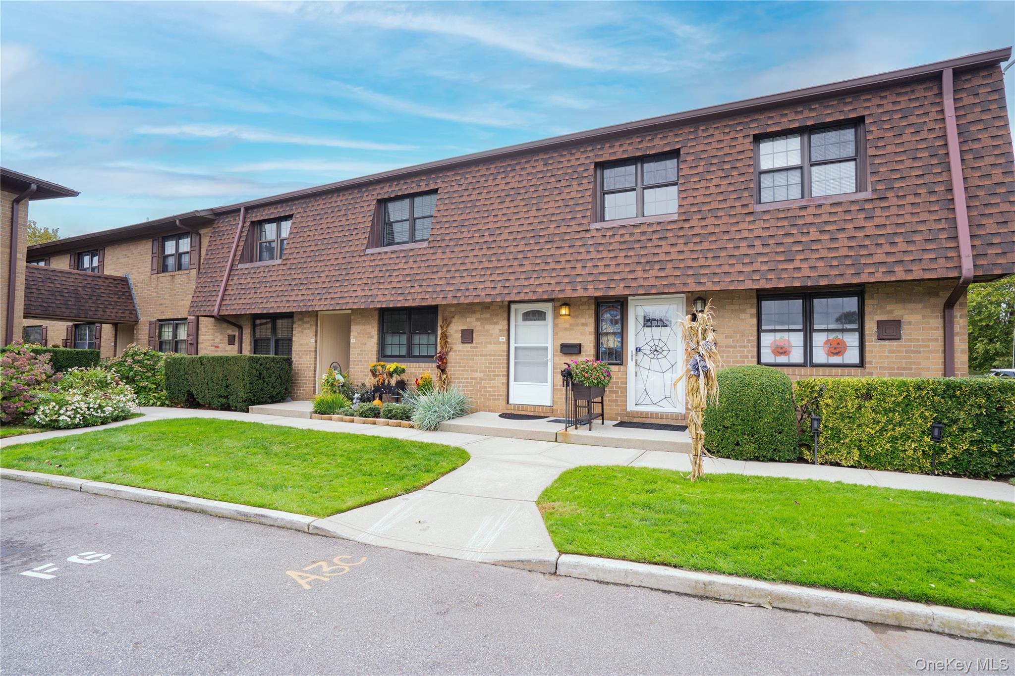 front view of a brick house with a yard