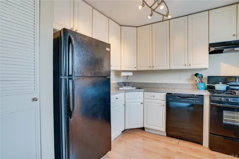 a kitchen with stainless steel appliances granite countertop a refrigerator a stove and a sink