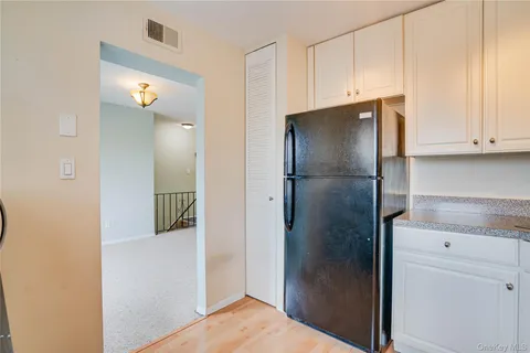 a view of kitchen cabinets and refrigerator