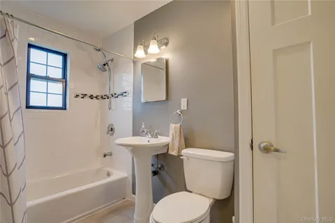 a white toilet sitting next to a bathroom sink and tub