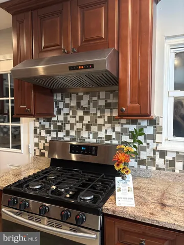 a kitchen with granite countertop a stove and cabinets