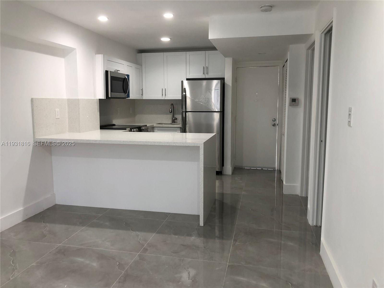 a kitchen with kitchen island a sink appliances and cabinets