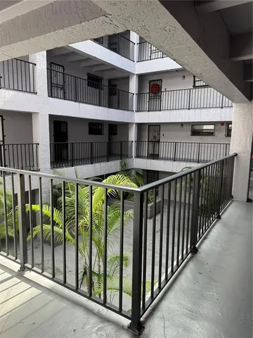 a view of a brick house with plants and wooden deck