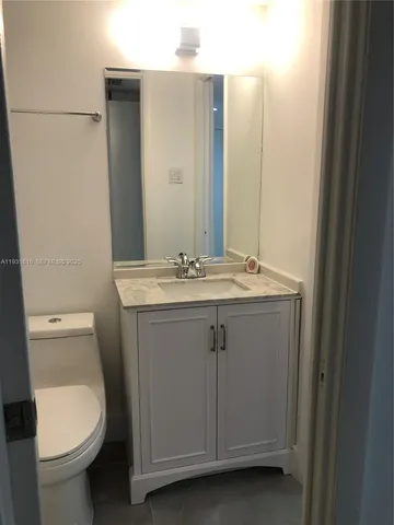 a bathroom with a sink toilet and mirror