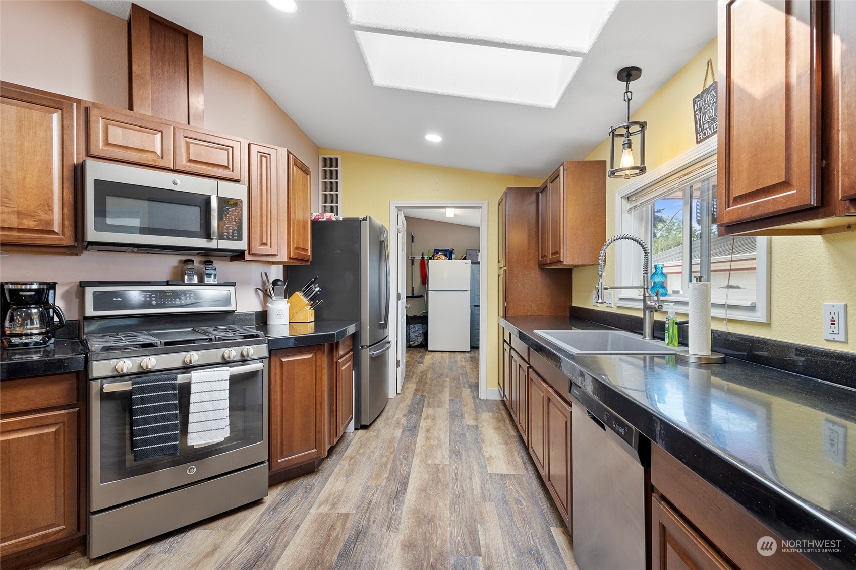 13846 Avon Allen Road Mount Vernon, WA 98273 - Photo 13 of 36 a kitchen with stainless steel appliances granite countertop a stove a sink dishwasher a refrigerator and a microwave oven with wooden floor