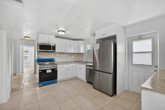 a kitchen with stainless steel appliances granite countertop a refrigerator sink and stove