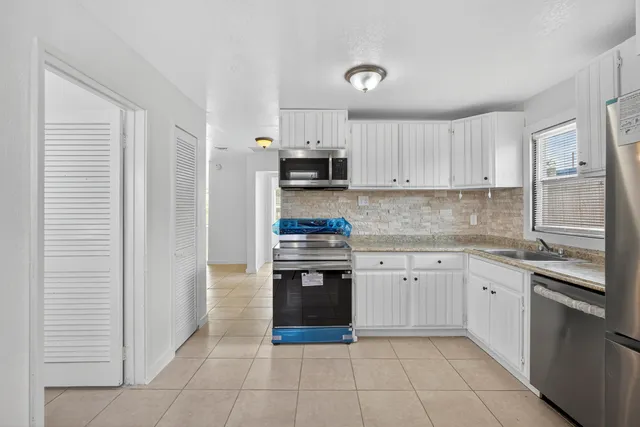 a kitchen with stainless steel appliances granite countertop a stove and a refrigerator