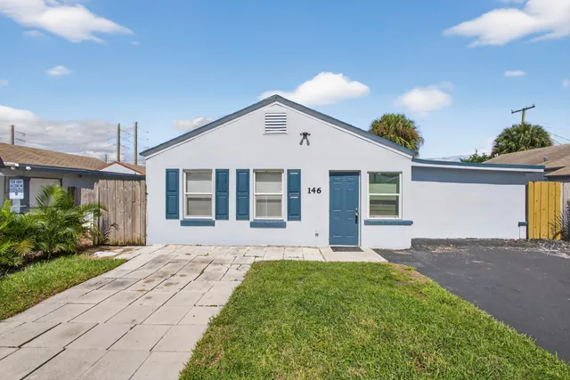 a front view of a house with a garden and yard