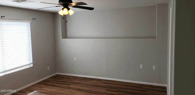 an empty room with a window and a fan