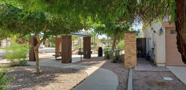 a view of a house with large trees and plants