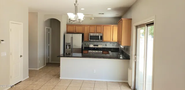a kitchen with stainless steel appliances granite countertop a refrigerator and a stove