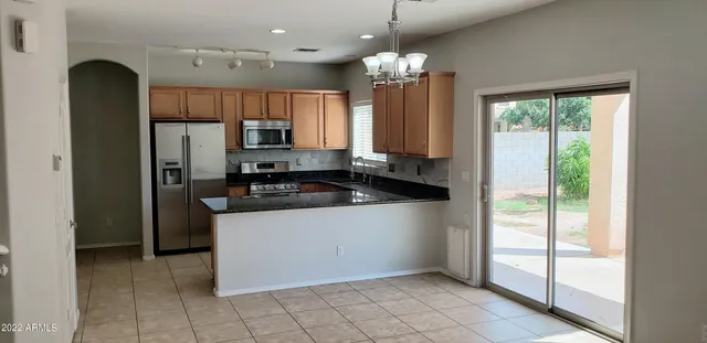 a kitchen with granite countertop a refrigerator and a sink