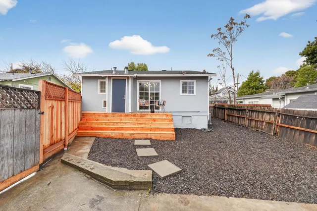 a view of a house with backyard and sitting area
