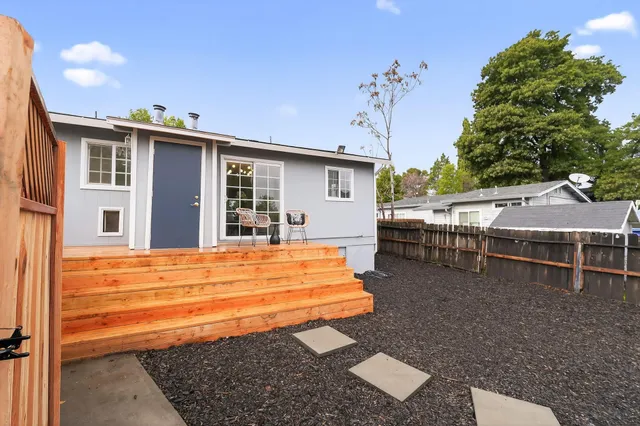 a backyard of a house with barbeque oven table and chairs