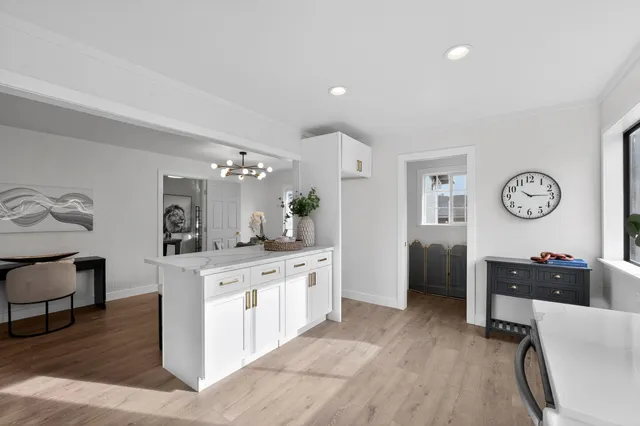 a open kitchen with cabinets a counter and chairs