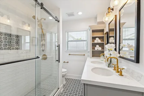 an empty room with wooden floor chandelier fan and windows