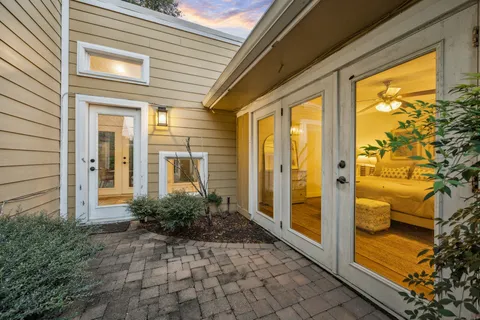 a view of a tennis ground with large trees
