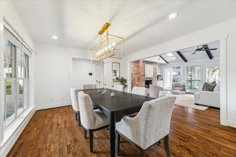 a dining room with furniture a chandelier and wooden floor