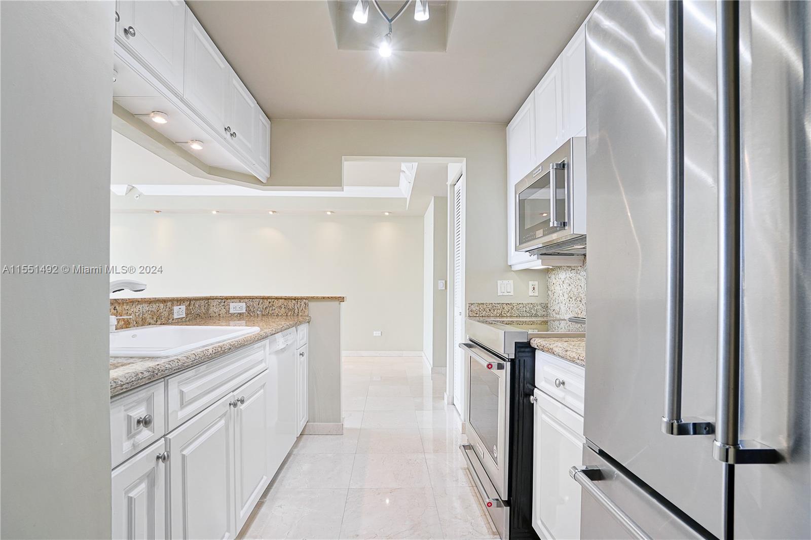 848 Brickell Key Drive, Unit 2003 Miami, FL 33131 - Photo 12 of 35 a spacious bathroom with a granite countertop sink and a mirror