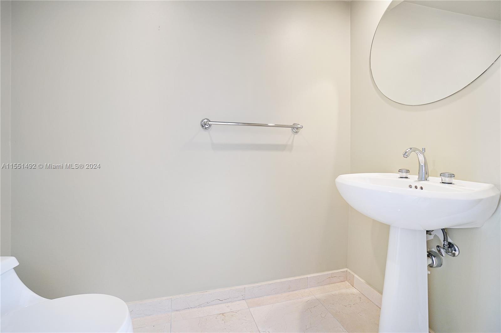 848 Brickell Key Drive, Unit 2003 Miami, FL 33131 - Photo 22 of 35 a bathroom with a sink a toilet and a mirror