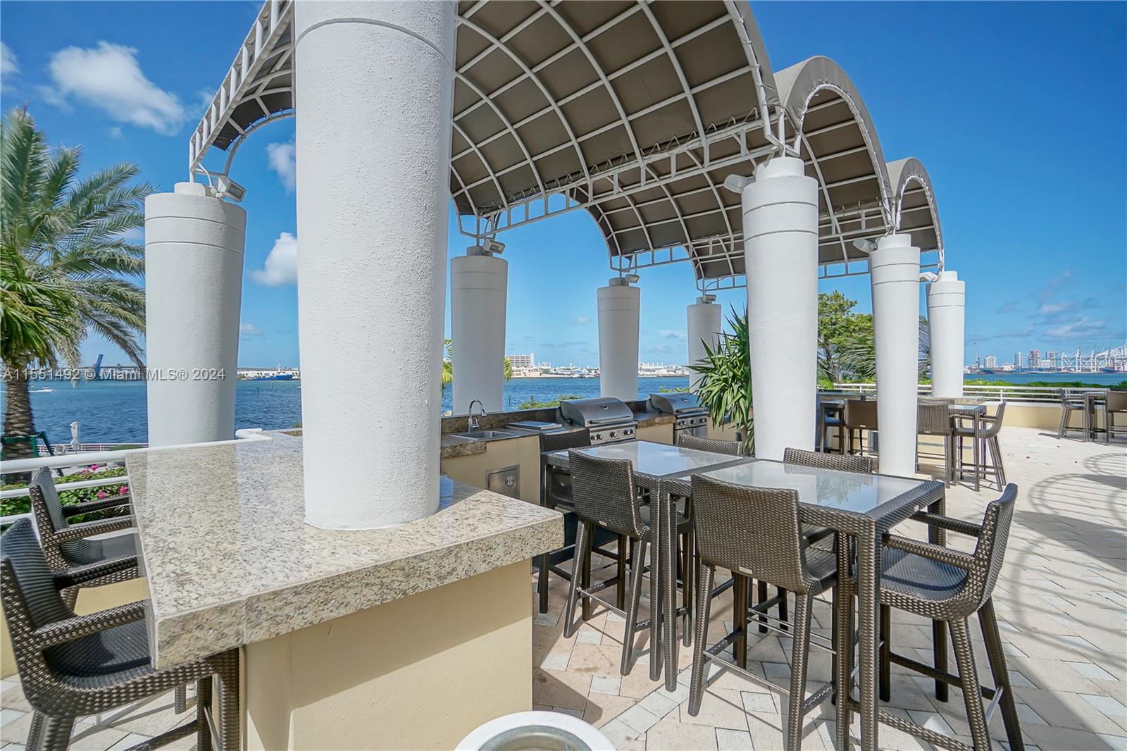 848 Brickell Key Drive, Unit 2003 Miami, FL 33131 - Photo 32 of 35 a view of a dining table and chairs in the patio