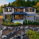 a front view of a house with a yard and potted plants