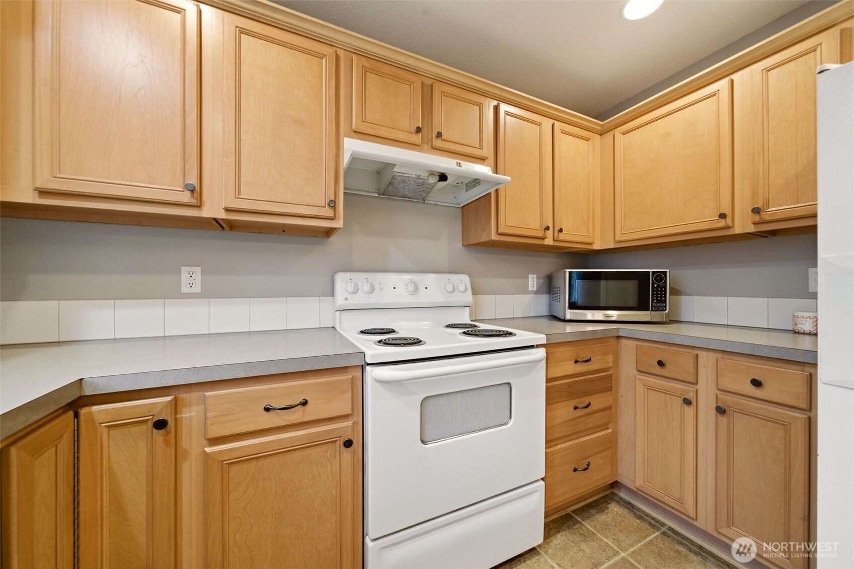 1205 Northeast 165th Way Ridgefield, WA 98642 - Photo 17 of 38 a kitchen with white cabinets and white appliances
