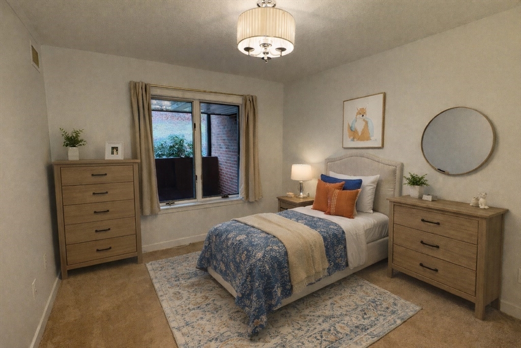 100 Rosemary Way, Unit 129 Needham, MA 02494 - Photo 12 of 20 a bedroom with a bed and a dresser
