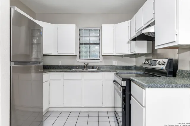 a kitchen with stainless steel appliances granite countertop a sink stove and cabinets