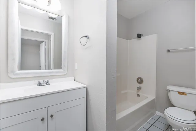 a bathroom with a sink a toilet a mirror and shower
