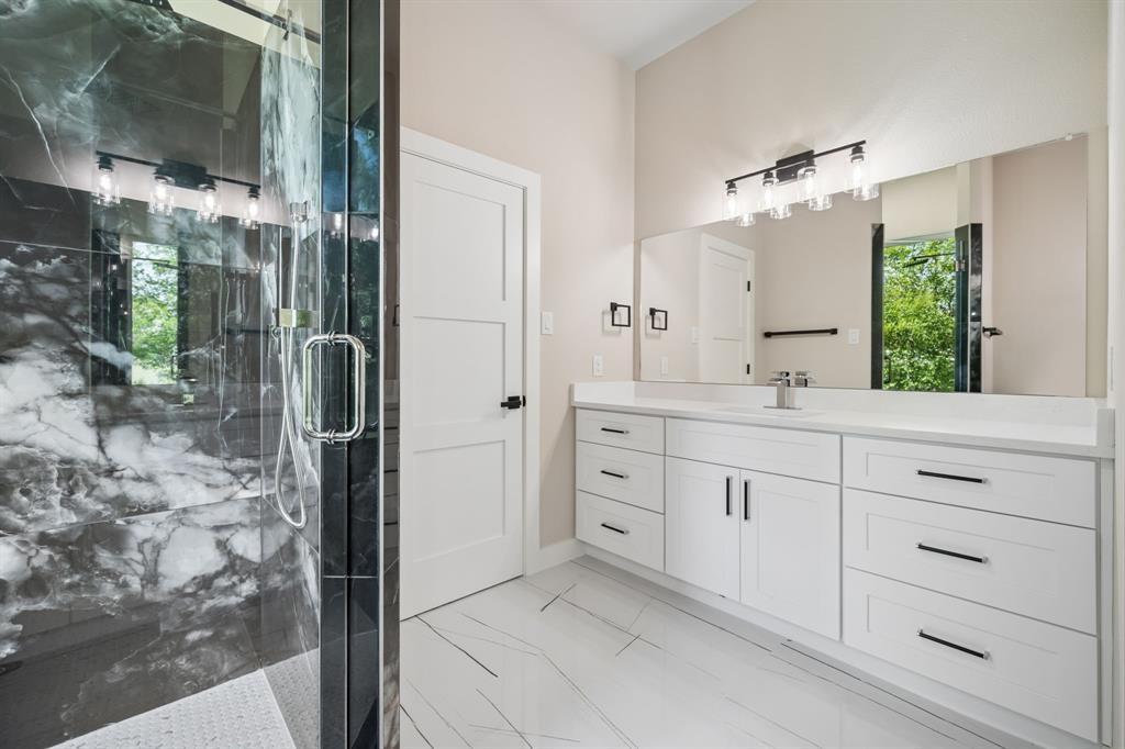 105 Buckboard Trail Oak Point, TX 75068 - Photo 14 of 27 Full bathroom with vanity and gorgeous, veined marble finish in shower.