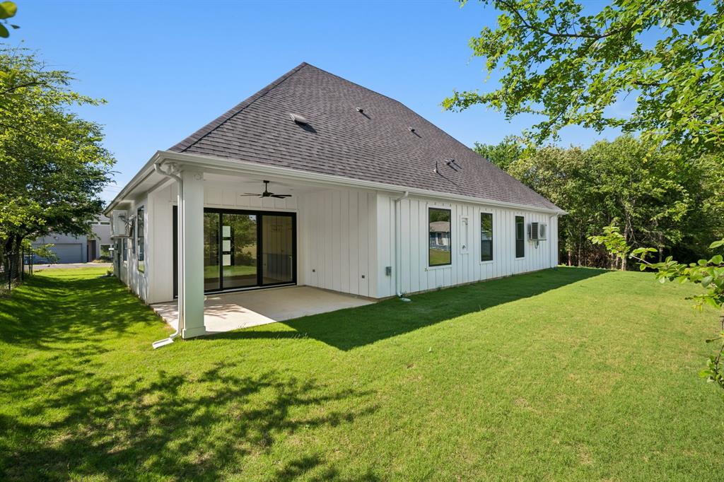 105 Buckboard Trail Oak Point, TX 75068 - Photo 22 of 27 Back of house featuring a patio area with ceiling fan and large yard.