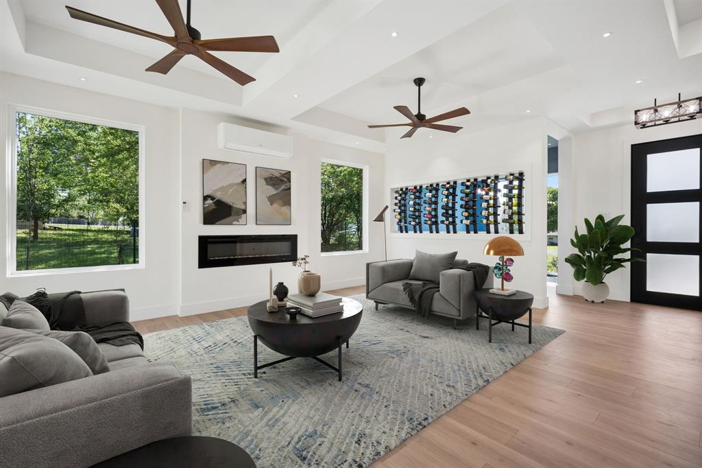 105 Buckboard Trail Oak Point, TX 75068 - Photo 4 of 27 Living Room with wine racks, electric fireplace, dual ceiling fans - virtually staged.