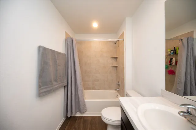 a bathroom with a bathtub shower sink vanity and toilet
