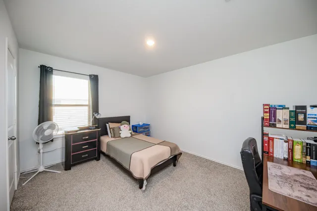 a bedroom with furniture and a book shelf