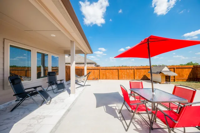 a view of patio with a table and chairs under an umbrella