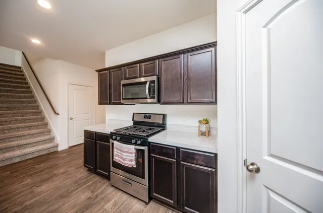 a kitchen with stainless steel appliances a stove a microwave and cabinets