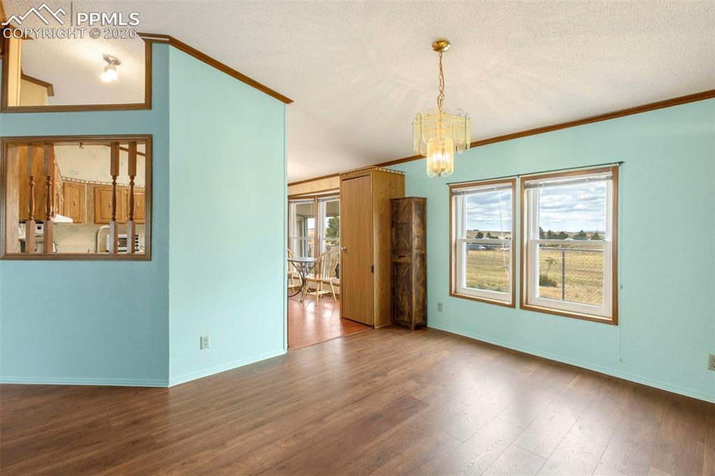 13335 Gymkhana Road Peyton, CO 80831 - Photo 17 of 38 Bright interior space featuring wood-finish flooring, light blue walls, and a decorative chandelier