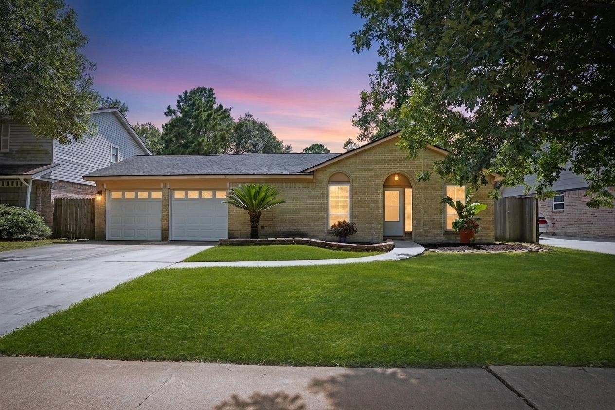 17119 Mellow Ridge Drive Spring, TX 77379 - Photo 1 of 32 This inviting single-story brick home features a two-car garage and a well-maintained front lawn with mature trees. The warm exterior lighting and a curved walkway enhance its curb appeal, creating a welcoming atmosphere.