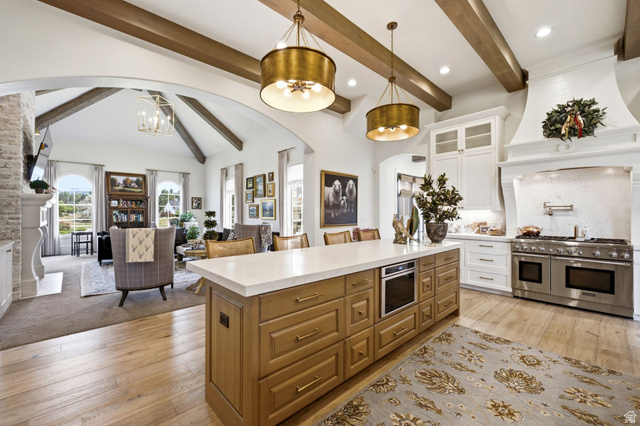 71 Farm Road Midway, UT 84049 - Photo 17 of 92 Gourmet kitchen featuring a large central island with integrated microwave, stainless steel professional-grade range with double ovens, custom range hood, and crisp white cabinetry