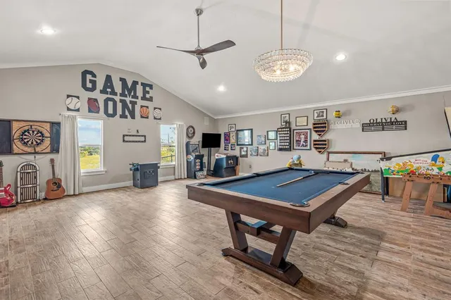 a living room with furniture pool table flat screen tv and window