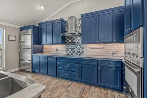 a kitchen with stainless steel appliances granite countertop wooden cabinets a refrigerator and a sink