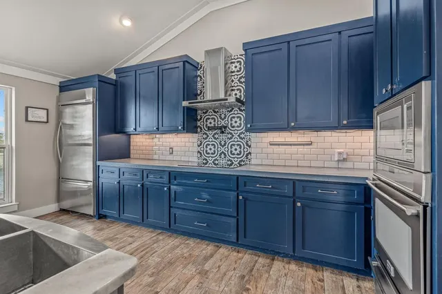 a kitchen with stainless steel appliances granite countertop wooden cabinets a refrigerator and a sink