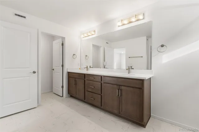 a spacious bathroom with a double vanity sink mirror and double