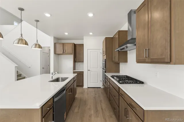 a kitchen with stainless steel appliances kitchen island a sink stove and refrigerator