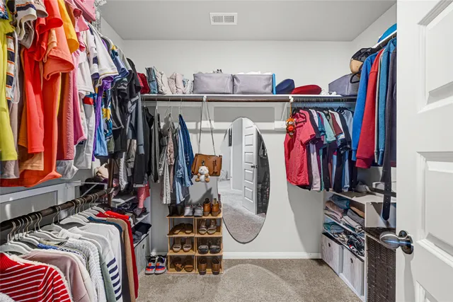 a view of walk in closet with clothes and shoes