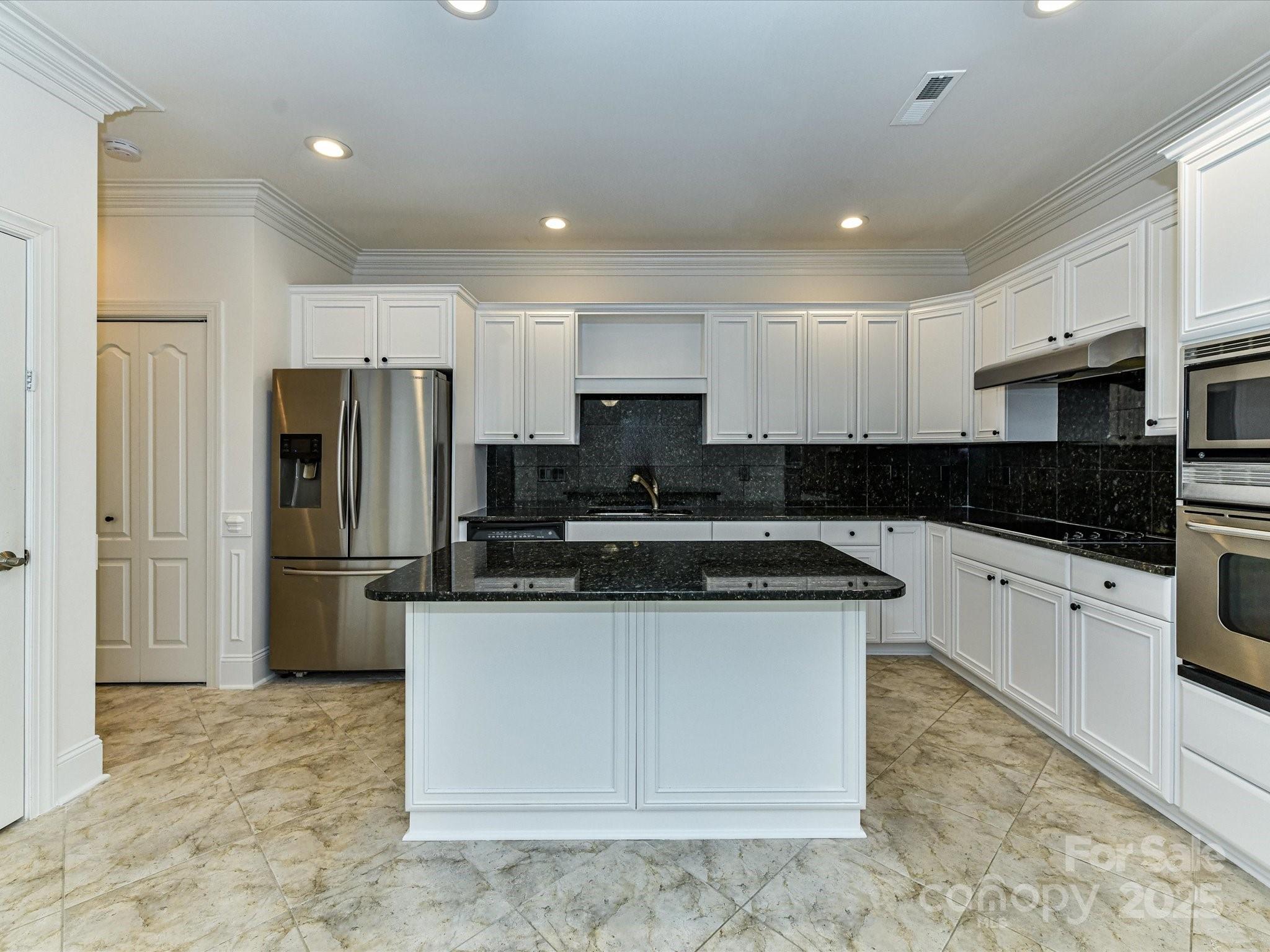 155 Harper Lee Street Davidson, NC 28036 - Photo 8 of 26 a kitchen with a sink a refrigerator and cabinets