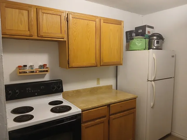 a kitchen with a refrigerator and a stove
