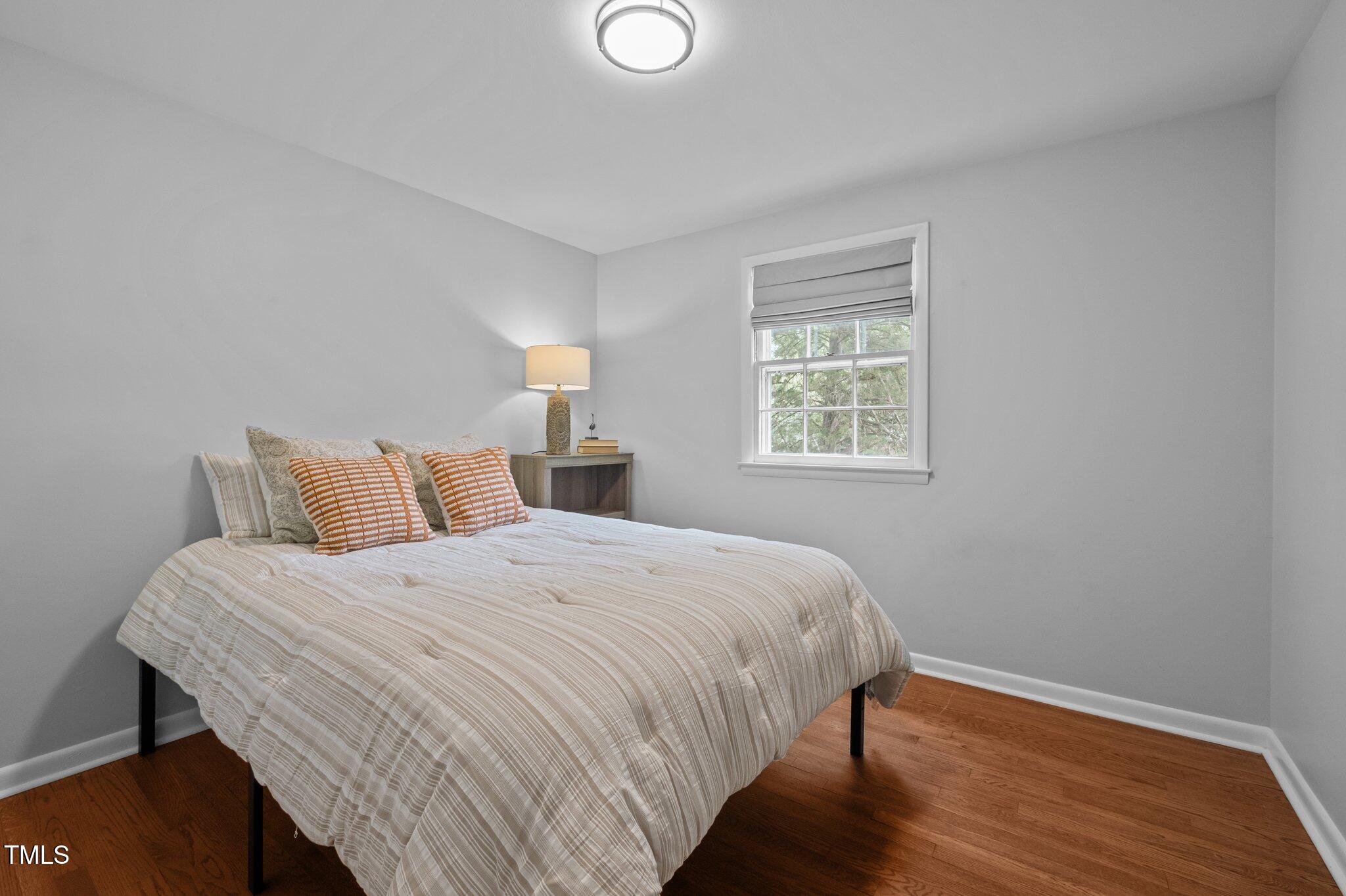 1205 Willow Drive Chapel Hill, NC 27517 - Photo 17 of 45 a bedroom with a bed and wooden floor